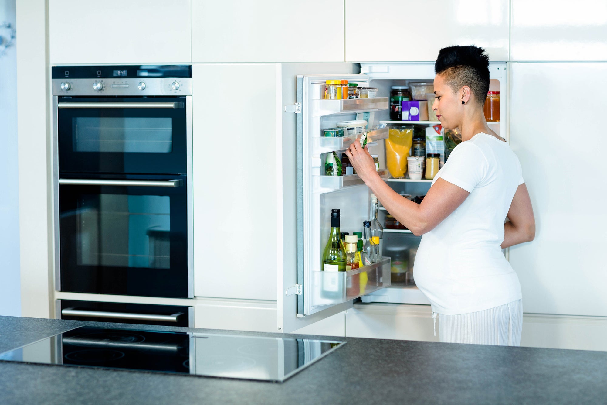 Pregnant woman looking in the refrigerator. Safety First: hidden toxins to avoid during pregnancy